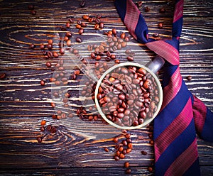 Cup of coffee, grain, professional  celebration `s tie on a wooden background