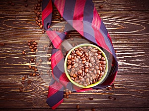 Cup of coffee, grain, professional `s tie on a wooden background