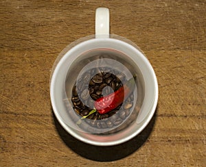 Cup of coffee grains red hot pepper