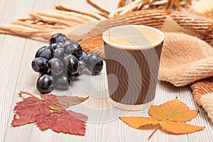 Cup of coffee, grapes and dry leaves in an autumn still llife