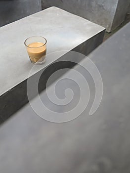 A cup of coffee on a gray cement table