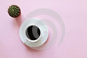 A cup of coffee and green cactus plant