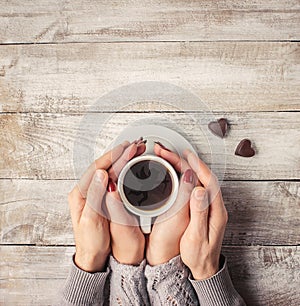 A cup of coffee in the hands of lovers. Silhouette in a cup.