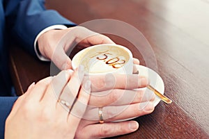 Cup of coffee and hands newlywed