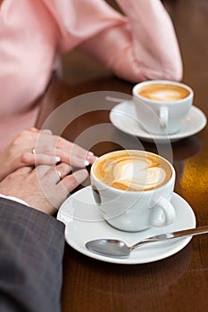 Cup of coffee and hands newlywed