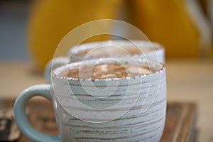 Cup of coffee with heart pattern in a white cup on wooden background