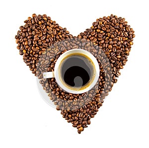 Cup of coffee and a heart shape made of roasted coffee beans