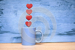 Cup of coffee with hearts on a wooden background