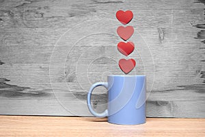 Cup of coffee with hearts on a wooden background