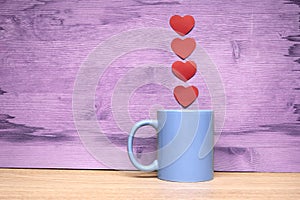 Cup of coffee with hearts on a wooden background