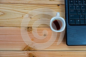 a cup of coffee with labtop on wood desk photo