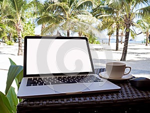 A cup of coffee beside laptop with Coconut tree and sea view, white sand beach background, .Travel plans after retirement of