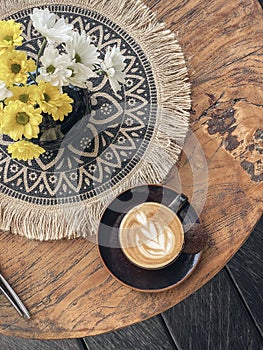 A cup of coffee with latte art on top on wooden table