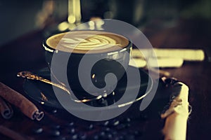 Cup of coffee with latte art on vintage wooden table