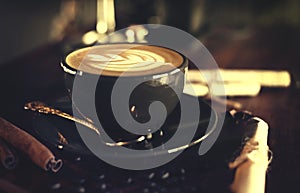 Cup of coffee with latte art on vintage wooden table