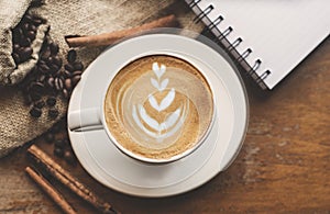 Cup of coffee with latte art on vintage wooden table