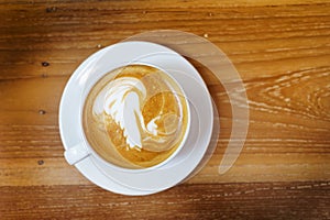Cup of coffee latte art on wooden table background with space from top view