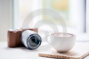 Cup of coffee latte and classic camera on white table