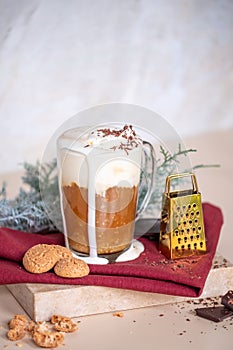 Cup of coffee latte, cookies in Christmas mood. Small gold grater for chocolate