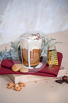 Cup of coffee latte, cookies in Christmas mood. Small gold grater for chocolate