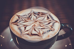 Cup of coffee latte with design art in froth, on a