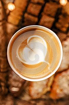 Cup of coffee latte to go with tasty pastry background , sunlight