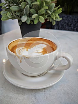 A cup of coffee latte on a white marble table, focusing on the coffee stain on the cup after drink