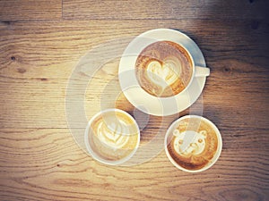 Cup of coffee with a lot of beautiful latte art on wooden table with vintage style
