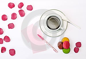 Cup with coffee and macrons, pen and note paper
