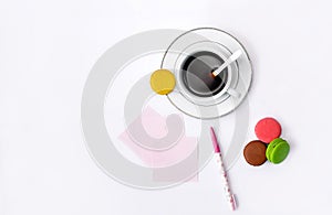 Cup with coffee and macrons, pen and note paper