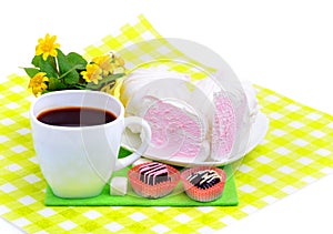 Cup of coffee with marshmallow, chocolate sweets, yellow wildflowers isolated on white