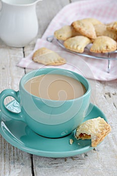 Cup of coffee with milk and apple pies on wooden background