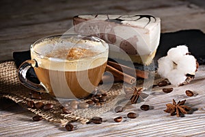 Cup of coffee with milk and cheesecake on a wooden background.