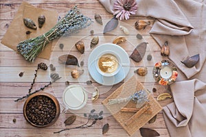 A cup of coffee, milk, coffee beans, gift box on a wooden background