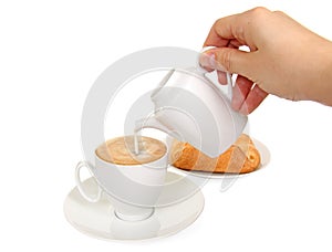 Cup of coffee, milk jug and fresh bakery