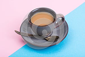 Cup of coffee with milk on pastel background