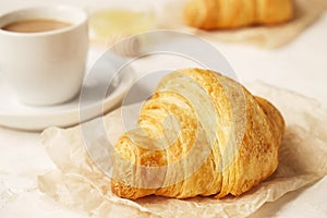 Delicious morning coffee cup with croissant close up on white