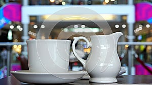 A cup of coffee and a milkman on a table in the cafe business center