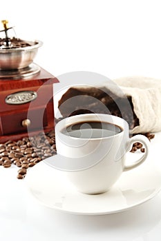 Cup of coffee with mill,bag full of coffee beans on white photo