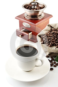 Cup of coffee with mill,bag full of coffee beans on white photo