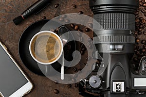 Cup of coffee with mobil phone and camera on rustic background.