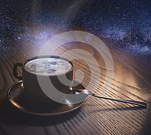 A cup of coffee with the moon and clouds on the background of the night sky. copyspace. The concept of inspiration and creativity