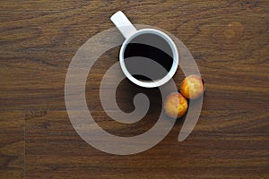 Cup of coffee and muffins on wooden table