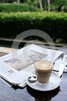 Cup of coffee with news paper on table