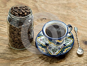 Cup of coffee next to jar of beans