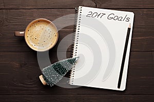 Cup of coffee and notebook with goals for 2017. Planning and motivation for the new year concept. Top view.