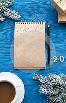 Cup of coffee and notebook with goals for new year