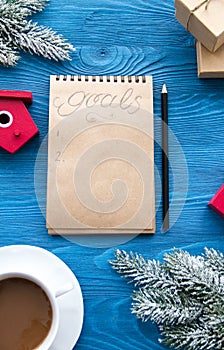 Cup of coffee and notebook with goals for new year