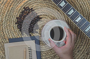 Cup of coffee with notebook on a jute rope.