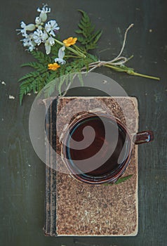 Cup of coffee with old vintage book on the table